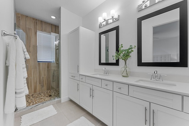 bathroom with tile patterned flooring, vanity, and a tile shower