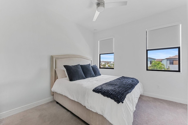 carpeted bedroom with multiple windows and ceiling fan