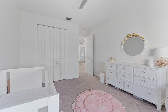 bedroom featuring ceiling fan, a closet, and light colored carpet