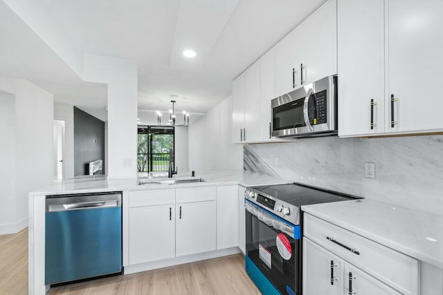 kitchen featuring white cabinetry, appliances with stainless steel finishes, and kitchen peninsula