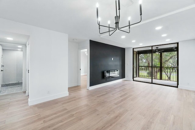 unfurnished living room featuring expansive windows, a large fireplace, and light wood-type flooring