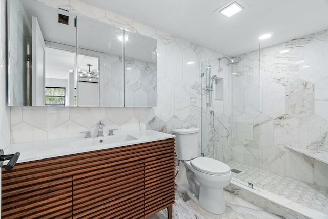 bathroom with a shower with door, tile walls, backsplash, vanity, and toilet