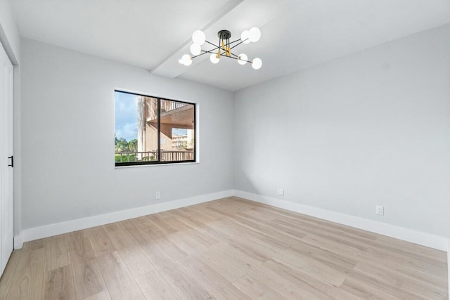 empty room with an inviting chandelier and light hardwood / wood-style floors