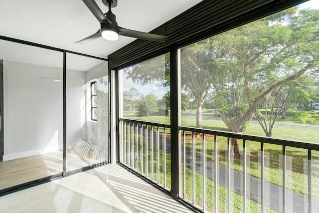 unfurnished sunroom with ceiling fan