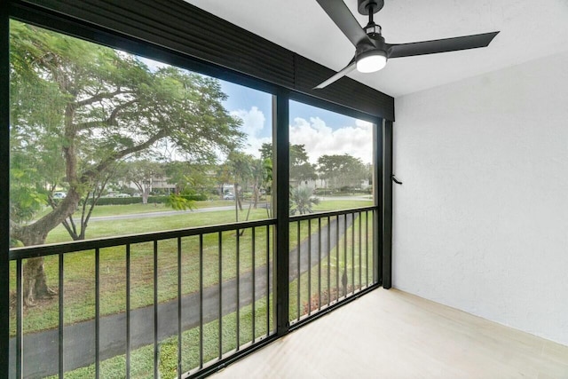 unfurnished sunroom featuring ceiling fan