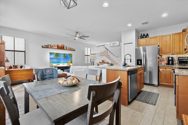 dining space featuring ceiling fan, light hardwood / wood-style floors, and sink