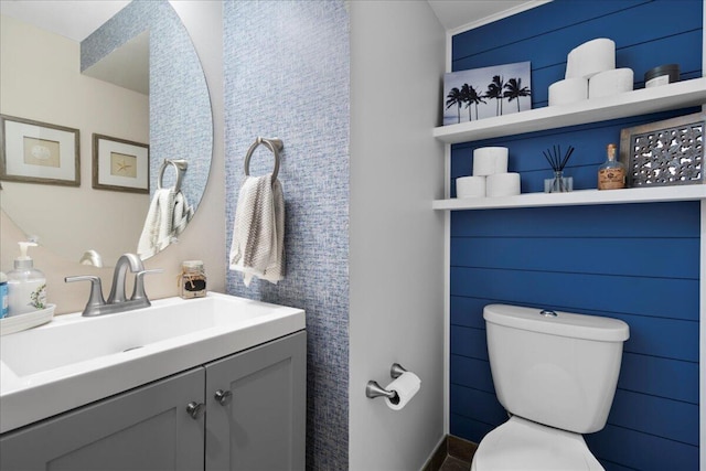 bathroom featuring vanity, tile walls, and toilet