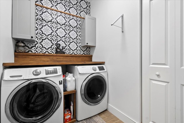 laundry area with washer and clothes dryer and cabinets