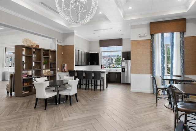 dining space featuring plenty of natural light, light parquet floors, ornamental molding, and a notable chandelier