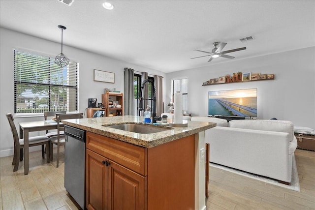 kitchen featuring dishwasher, a kitchen island with sink, sink, hanging light fixtures, and plenty of natural light