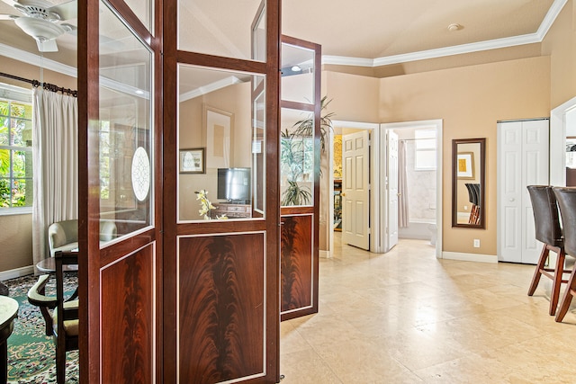 entrance foyer with crown molding and ceiling fan