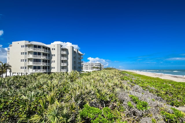 view of building exterior featuring a view of the beach and a water view