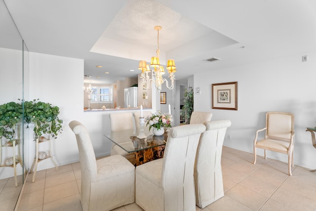 dining room with a raised ceiling, a notable chandelier, and light tile patterned flooring