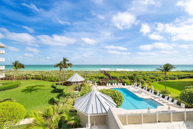 view of swimming pool with a patio, a water view, and a lawn