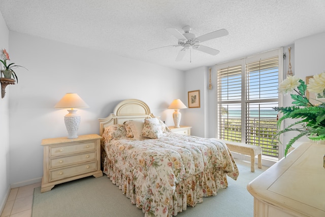 tiled bedroom featuring a textured ceiling and ceiling fan