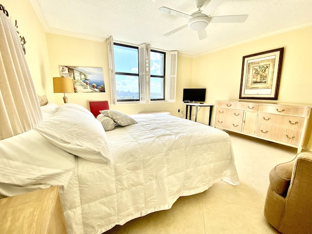 tiled bedroom with a textured ceiling, ceiling fan, and ornamental molding