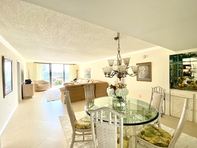 tiled dining room featuring ornamental molding, a textured ceiling, and a notable chandelier