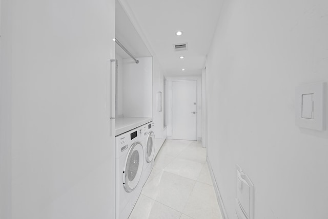 laundry area featuring washing machine and clothes dryer and light tile patterned floors