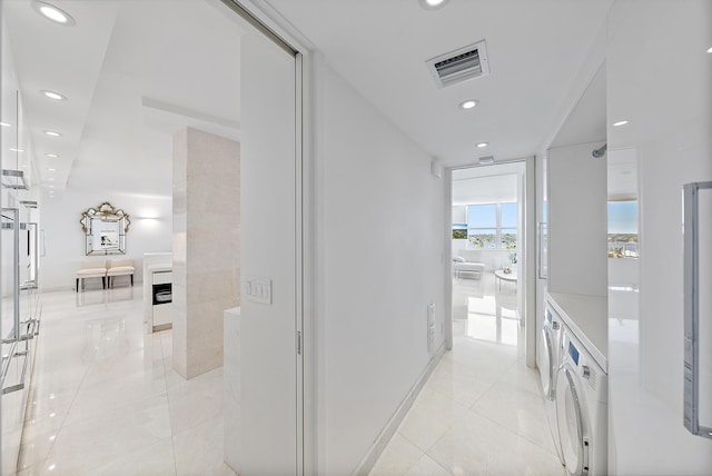 hallway featuring light tile patterned floors and washer / dryer