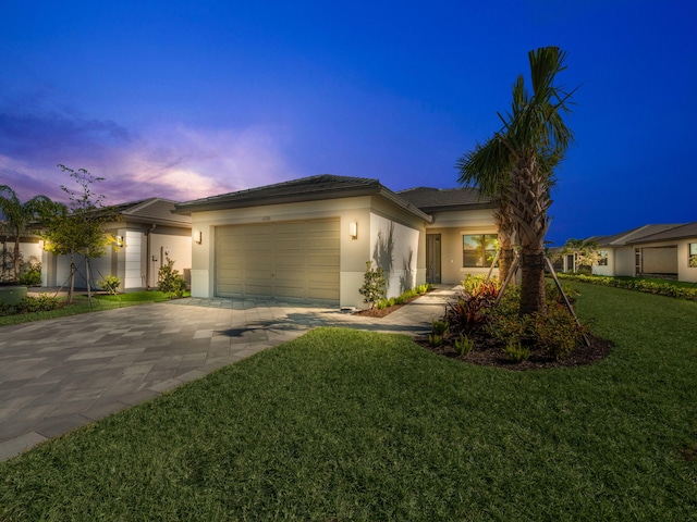 view of front of home with a garage and a yard