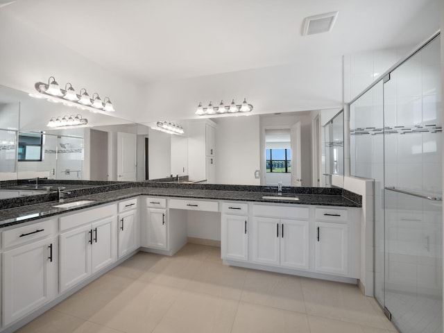 bathroom with tile patterned flooring, vanity, and a shower with shower door