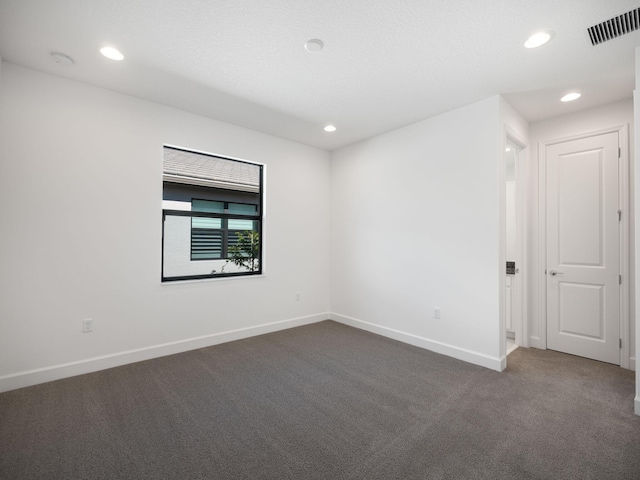 empty room with dark colored carpet