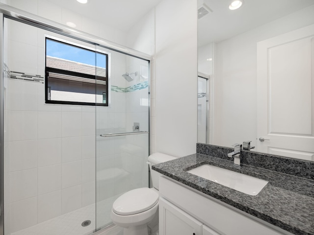 bathroom featuring vanity, toilet, and walk in shower