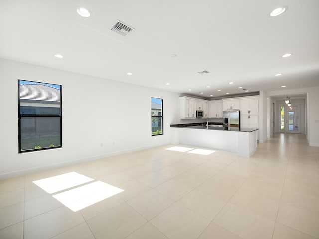 unfurnished living room featuring light tile patterned floors and a wealth of natural light