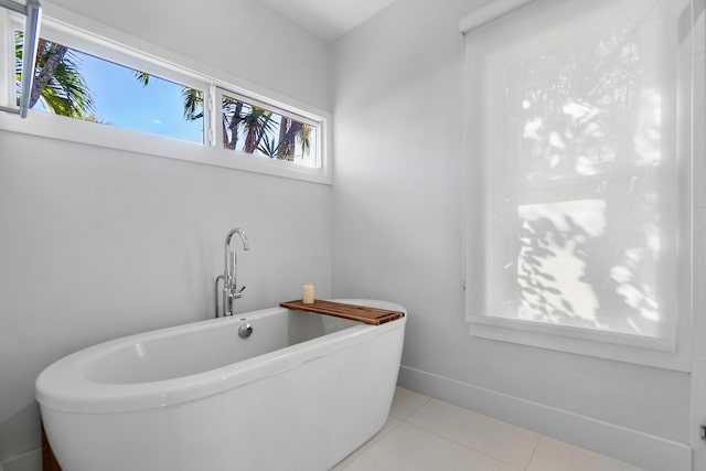 bathroom with tile patterned floors and a washtub