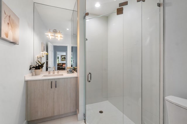 bathroom featuring tile patterned floors, vanity, an enclosed shower, and toilet