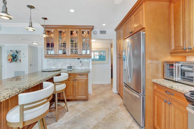 kitchen featuring stainless steel fridge, backsplash, light stone counters, crown molding, and pendant lighting