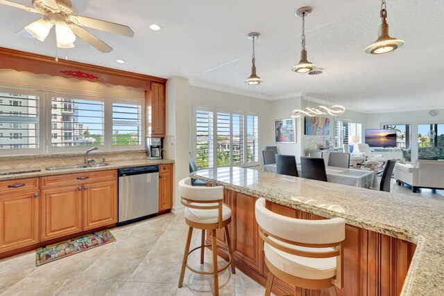 kitchen with light stone countertops, dishwasher, sink, a breakfast bar area, and ornamental molding