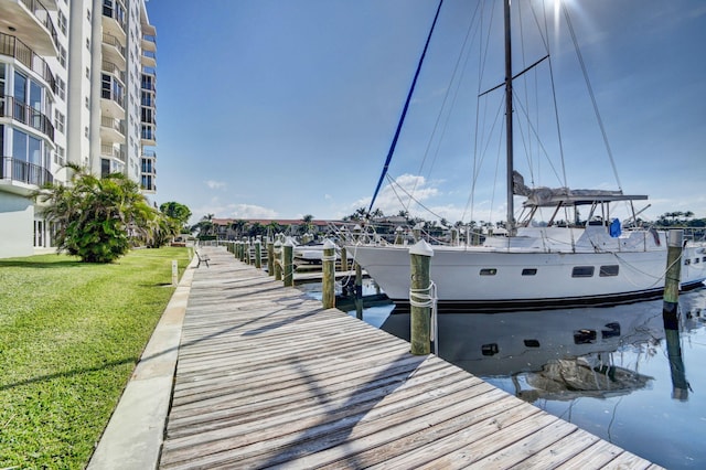 view of dock featuring a lawn and a water view