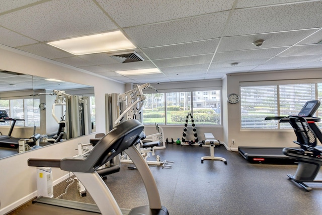 exercise room with a drop ceiling and a wealth of natural light