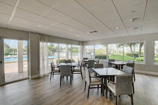 dining room with a paneled ceiling and wood-type flooring