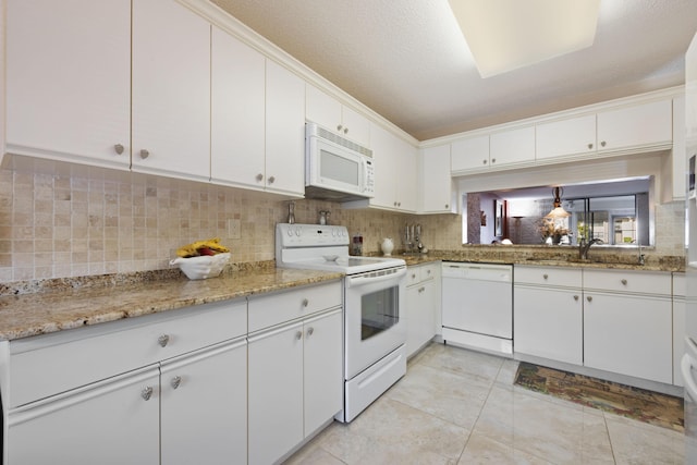 kitchen featuring white appliances, white cabinets, a textured ceiling, tasteful backsplash, and light tile patterned flooring