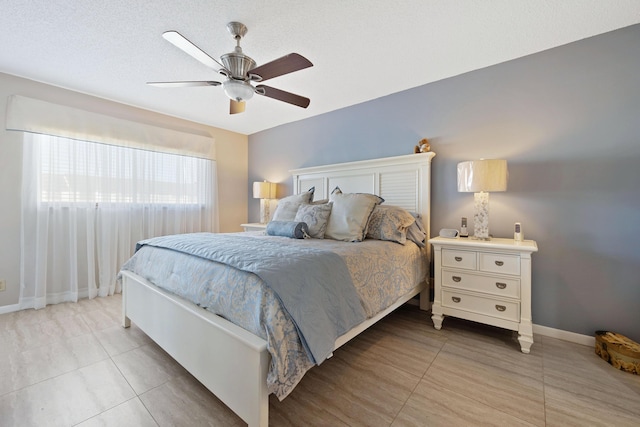 bedroom featuring ceiling fan and a textured ceiling