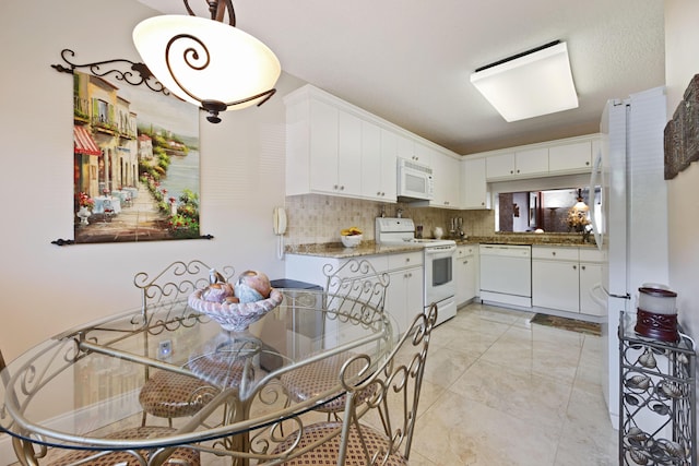 kitchen featuring white cabinets, decorative backsplash, white appliances, and light stone countertops