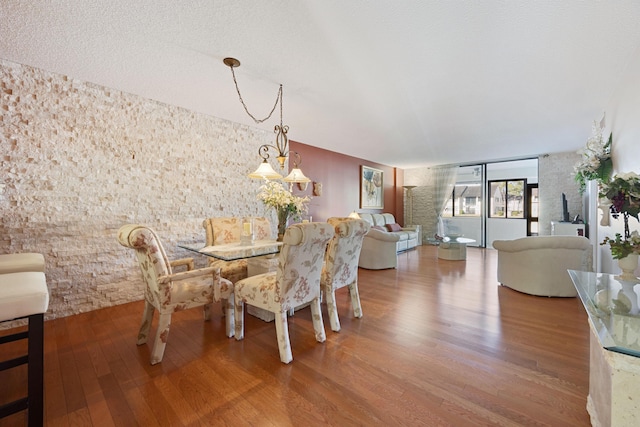 dining space with hardwood / wood-style floors and a notable chandelier