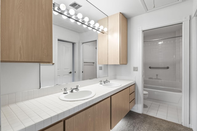 full bathroom with tile patterned flooring, vanity, toilet, and tiled shower / bath