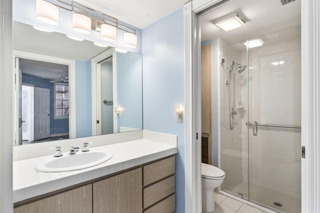 bathroom featuring tile patterned floors, vanity, an enclosed shower, and toilet