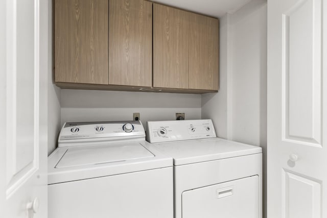 laundry area with washer and clothes dryer and cabinets