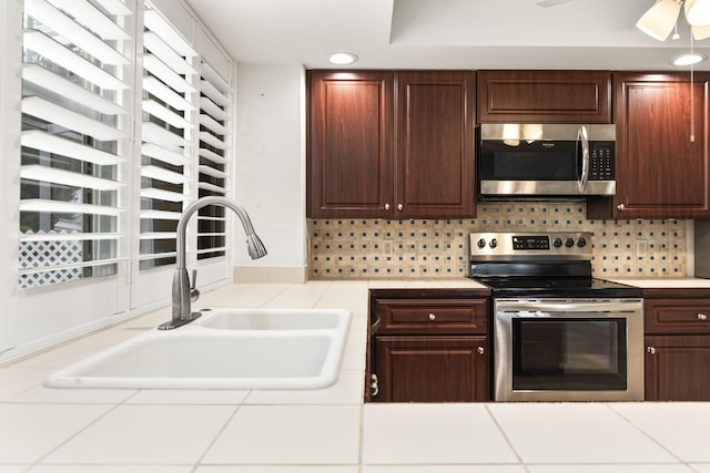 kitchen featuring tasteful backsplash, ceiling fan, sink, and stainless steel appliances