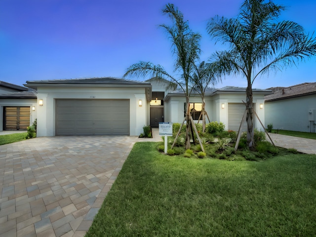 11282 SW Sea Cove Ln, Port Saint Lucie, FL 34987 - view of front facade featuring a garage, decorative driveway, stucco siding, and a front yard