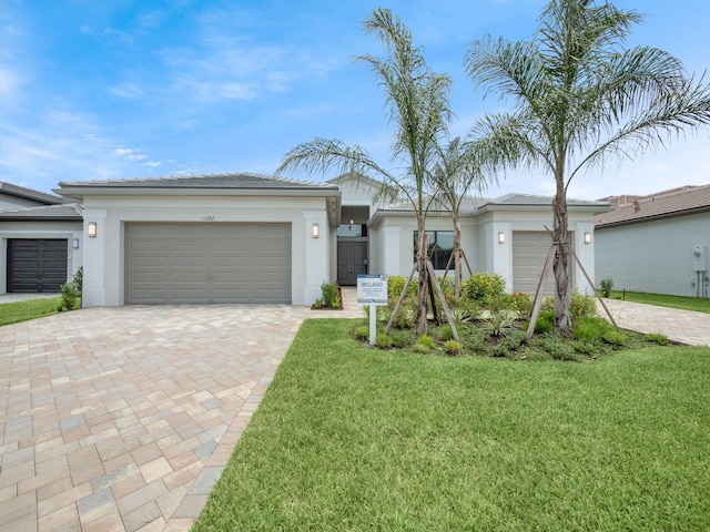 11282 SW Sea Cove Ln, Port Saint Lucie, FL 34987 - view of front of property with decorative driveway, a garage, stucco siding, and a front lawn