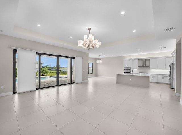 11282 SW Sea Cove Ln, Port Saint Lucie, FL 34987 - unfurnished living room featuring a tray ceiling, a chandelier, recessed lighting, baseboards, and light tile patterned flooring