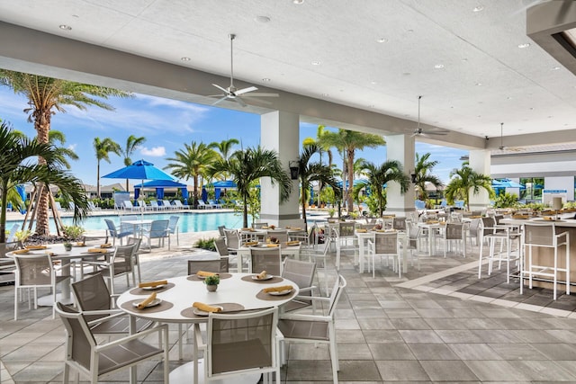 view of patio / terrace with ceiling fan and a community pool