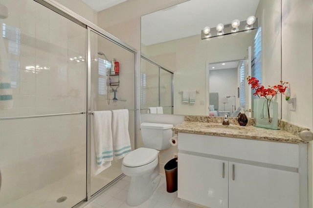 bathroom featuring tile patterned floors, a shower with door, vanity, and toilet