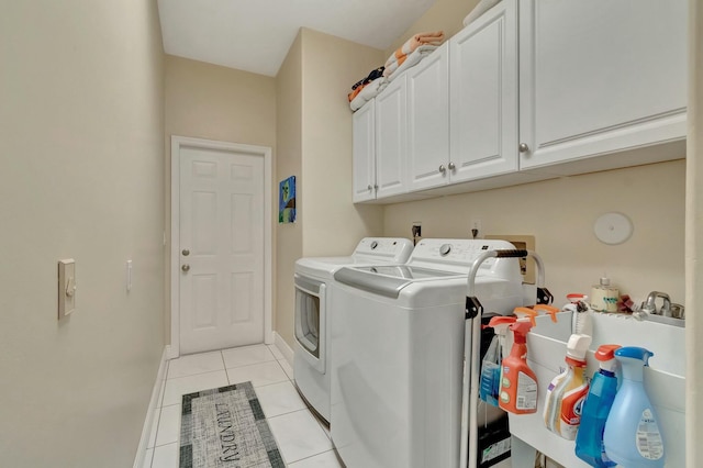 clothes washing area featuring cabinets, independent washer and dryer, and light tile patterned floors