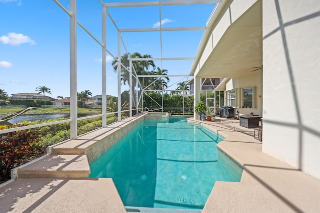 view of swimming pool with a lanai, a water view, and a patio